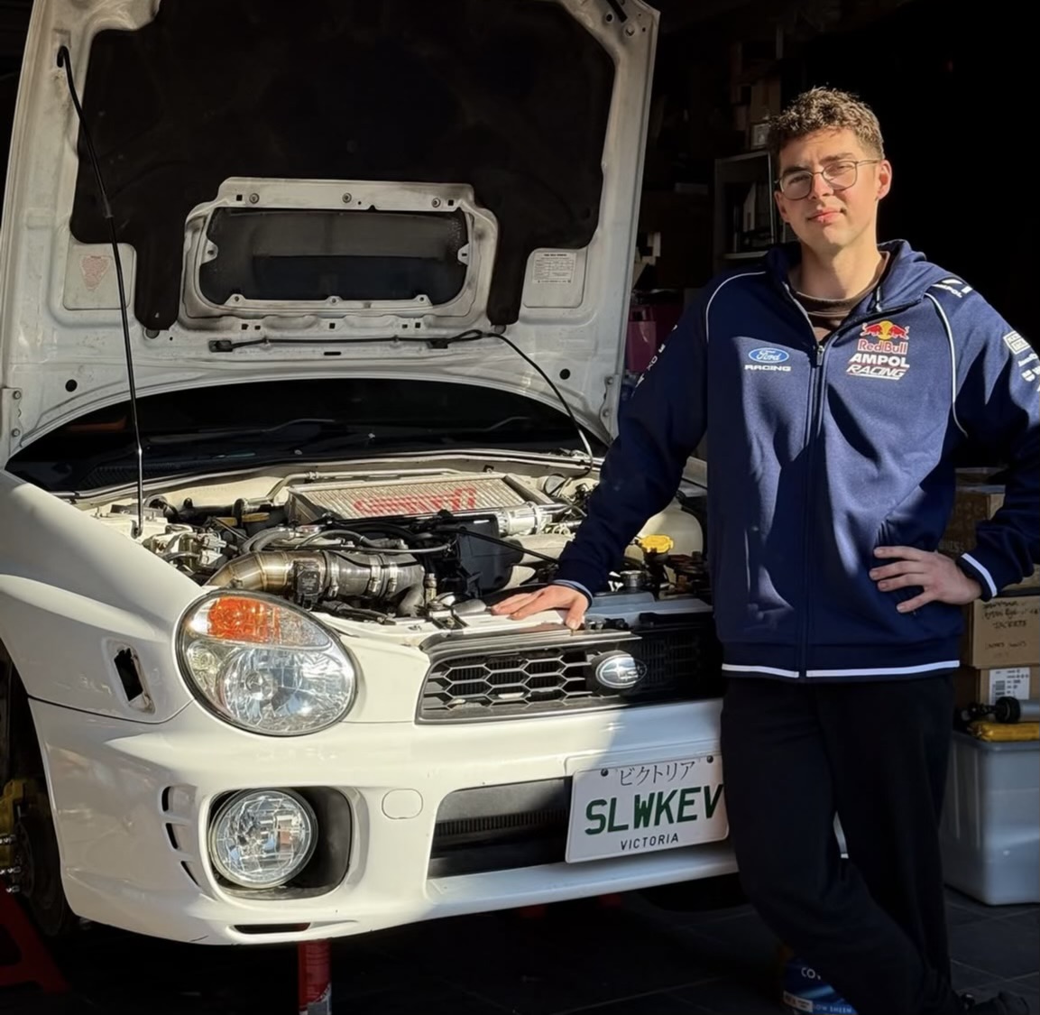 Kevin, founder of Stanjo Customs, with a Subaru build in the workshop
